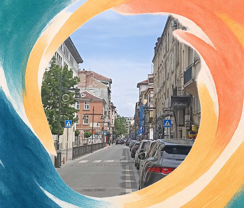 Paved empty street with some cars parked on the right side